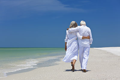 image of a retired couple walking on a beach